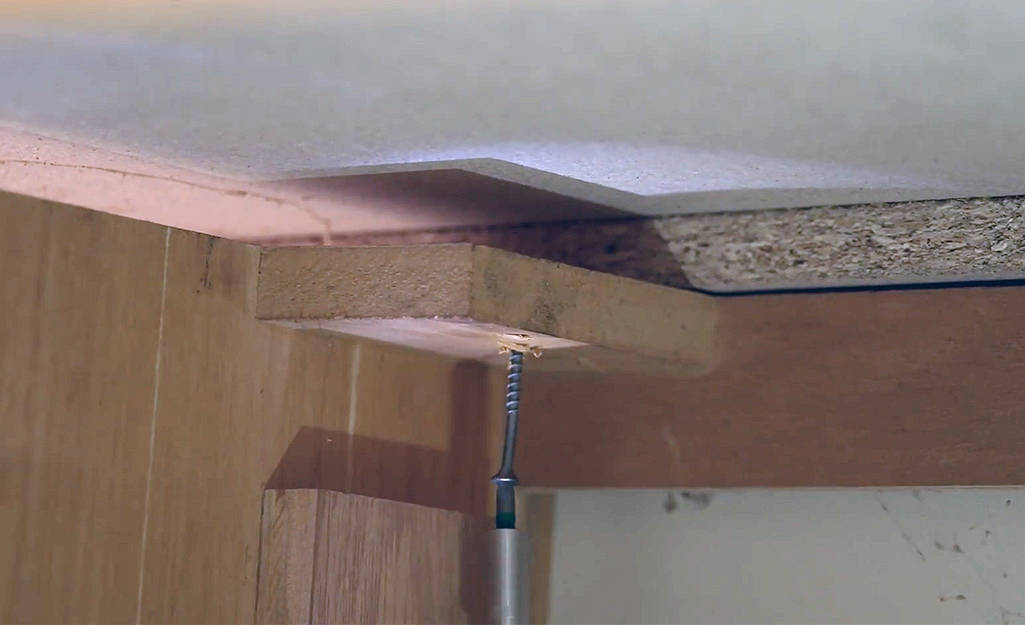attach laminate countertop to cabinet.